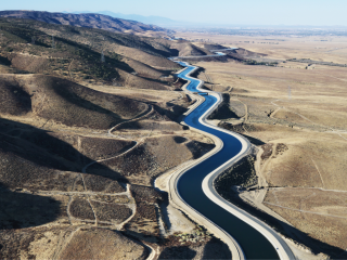 An overhead view of an aqueduct in the desert.